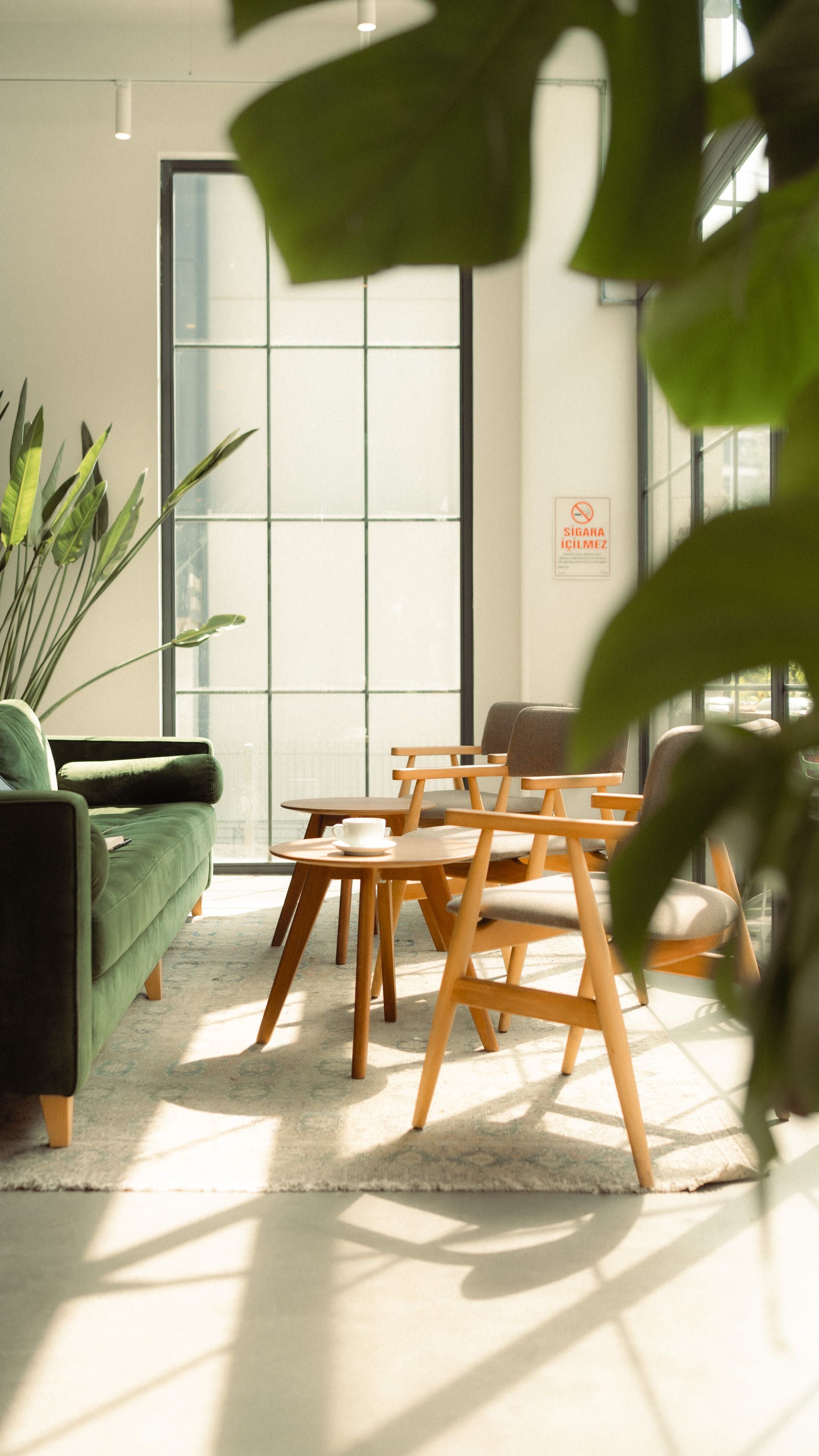 Modern living room with green sofa, wooden coffee table, and chairs.
